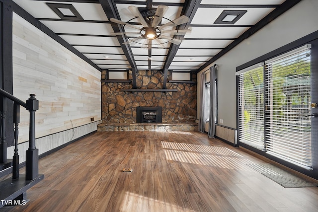 11316 Boggs Hollow Rd, Pound, VA 24279 - unfurnished living room with ceiling fan, a stone fireplace, beamed ceiling, wood finished floors, and wood walls