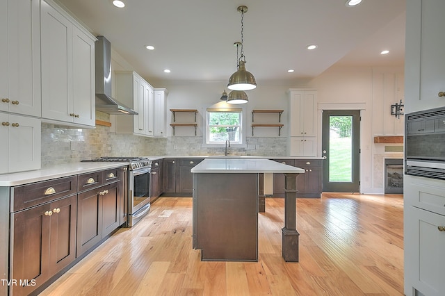 203 Riverwatch Cir, Kingsport, TN 37660 - kitchen with open shelves, stainless steel range with gas stovetop, wall chimney range hood, a breakfast bar, and light countertops