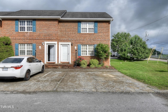 24 Lexington Ct Unit 6, Johnson City, TN 37615 - view of front of home featuring brick siding, a front yard, uncovered parking, and a shingled roof