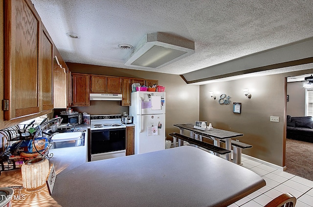 24 Lexington Ct Unit 6, Johnson City, TN 37615 - kitchen featuring white appliances, under cabinet range hood, brown cabinets, a textured ceiling, and light tile patterned floors