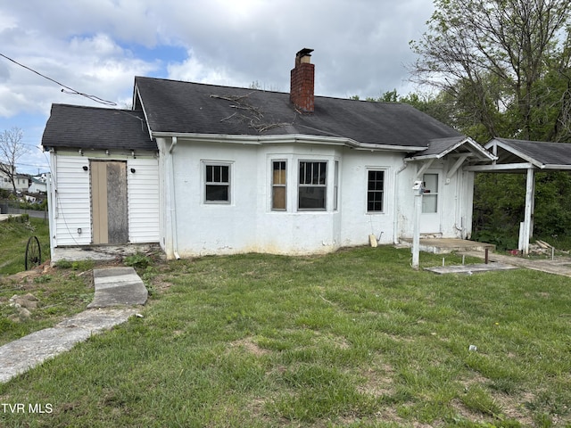 540 Madison St, Bristol, VA 24201 - rear view of house featuring a chimney, a yard, stucco siding, and roof with shingles
