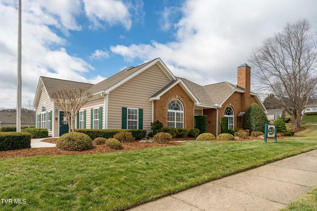 223 Avonlea Pl, Johnson City, TN 37604 - view of front of home with brick siding, a chimney, a front lawn, and roof with shingles