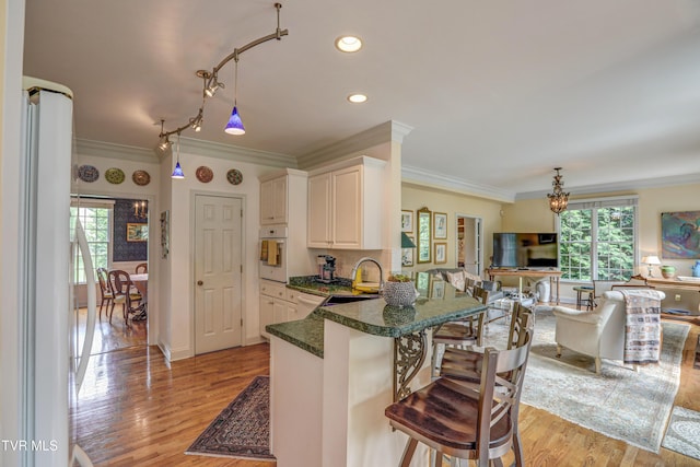 5621 John Gaines Blvd, Kingsport, TN 37664 - kitchen featuring white appliances, a sink, ornamental molding, open floor plan, and a kitchen breakfast bar