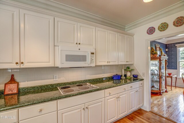 5621 John Gaines Blvd, Kingsport, TN 37664 - kitchen with white microwave, electric cooktop, light wood-type flooring, crown molding, and decorative backsplash