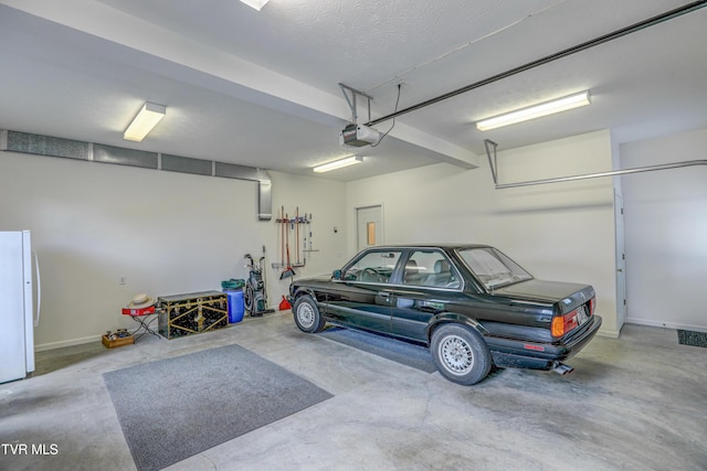 5621 John Gaines Blvd, Kingsport, TN 37664 - garage with freestanding refrigerator, a garage door opener, and baseboards