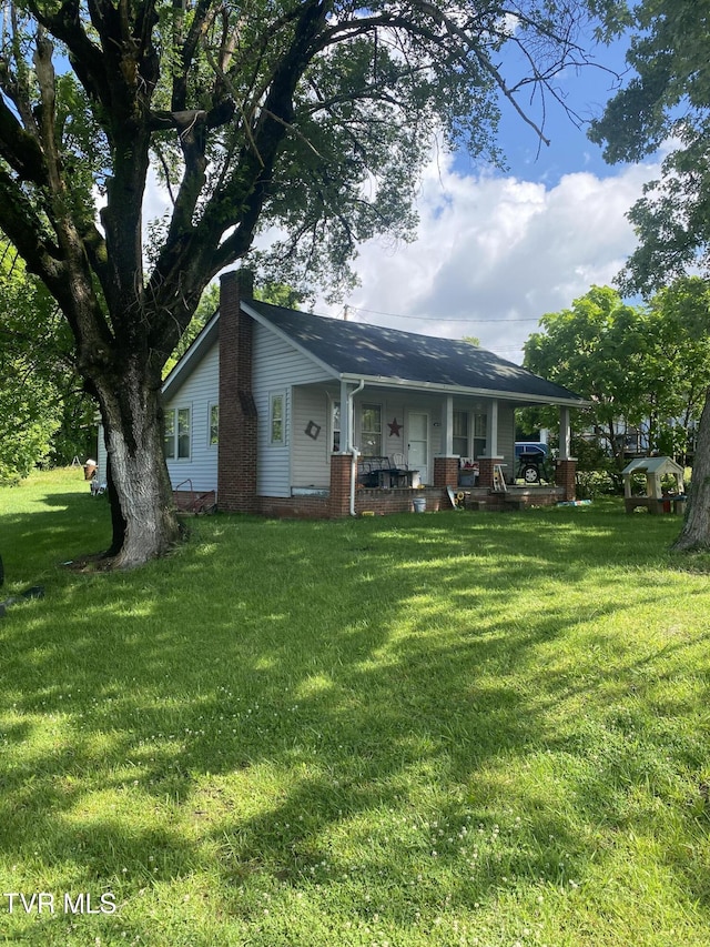 4228 Sullivan Gardens Dr, Kingsport, TN 37660 - rear view of house featuring a porch, a yard, and a chimney