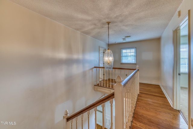 3510 Bondwood Cir, Johnson City, TN 37604 - corridor with an upstairs landing, a textured ceiling, wood finished floors, a chandelier, and baseboards