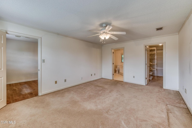3510 Bondwood Cir, Johnson City, TN 37604 - unfurnished bedroom featuring a walk in closet, carpet floors, a closet, ensuite bath, and a textured ceiling