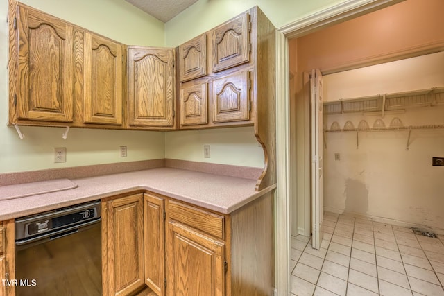 3510 Bondwood Cir, Johnson City, TN 37604 - kitchen featuring light countertops, light tile patterned floors, and brown cabinetry