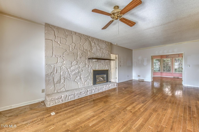 3510 Bondwood Cir, Johnson City, TN 37604 - unfurnished living room with a textured ceiling, ceiling fan, wood finished floors, a fireplace, and baseboards