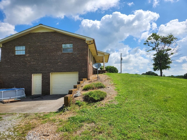 7083 Saint Clair Rd, Whitesburg, TN 37891 - view of side of home with a garage, brick siding, a lawn, and driveway
