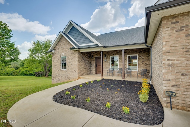 1 Sweetwood Dr, Johnson City, TN 37615 - view of exterior entry featuring a lawn, brick siding, and a shingled roof