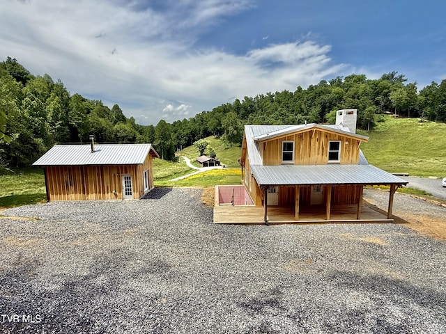 538 Punkton Rd, Del Rio, TN 37727 - view of front of home featuring metal roof, gravel driveway, board and batten siding, a forest view, and a chimney