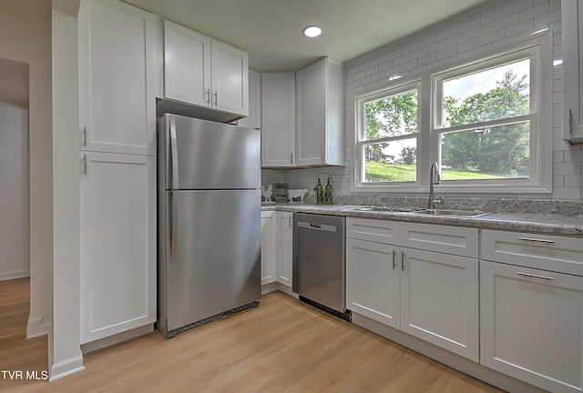 2221 Elizabethton Hwy, Johnson City, TN 37601 - kitchen with appliances with stainless steel finishes, a sink, light wood-type flooring, backsplash, and white cabinetry