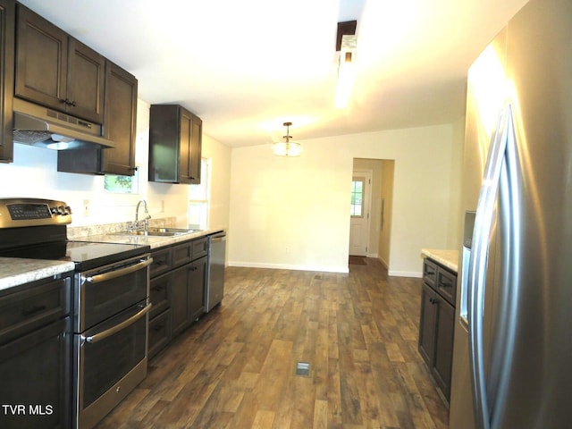 8929 Gateway Dr, Wise, VA 24293 - kitchen featuring appliances with stainless steel finishes, under cabinet range hood, a sink, dark wood-type flooring, and light countertops