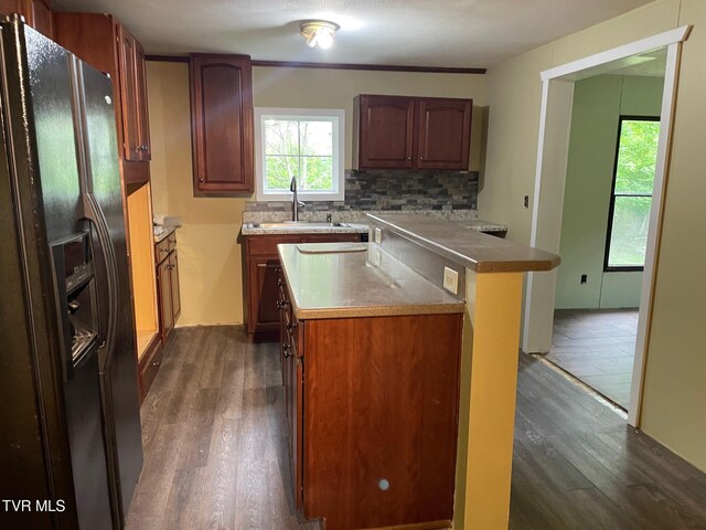 763 Sloantown Rd, Duffield, VA 24244 - kitchen with black fridge, dark wood-type flooring, a center island, and healthy amount of natural light