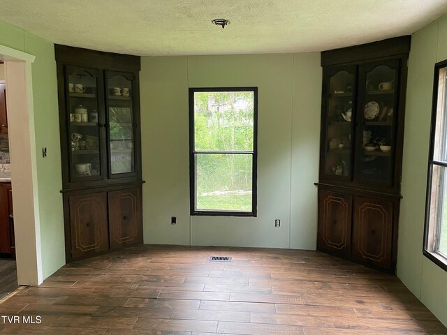 763 Sloantown Rd, Duffield, VA 24244 - unfurnished dining area with dark wood-type flooring, healthy amount of natural light, and a textured ceiling