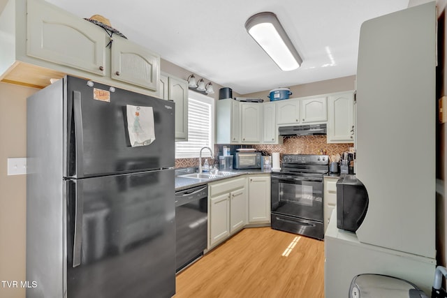 38 Lake Village Ct Unit 38, Johnson City, TN 37601 - kitchen with black appliances, under cabinet range hood, a sink, light wood-style floors, and decorative backsplash