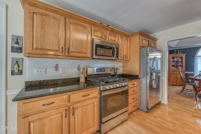 620 Glen Oaks Pl, Johnson City, TN 37615 - kitchen featuring appliances with stainless steel finishes, backsplash, dark stone countertops, and light wood-style floors