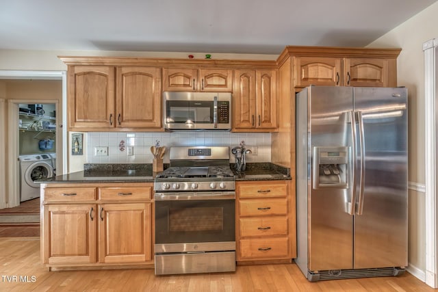 620 Glen Oaks Pl, Johnson City, TN 37615 - kitchen with stainless steel appliances, washer / clothes dryer, dark stone counters, light wood-type flooring, and tasteful backsplash