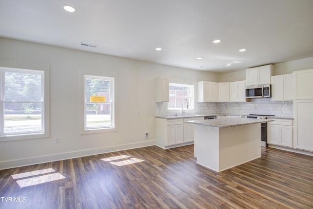 408 Levelin St, Erwin, TN 37650 - kitchen featuring appliances with stainless steel finishes, a sink, backsplash, light stone countertops, and a kitchen island