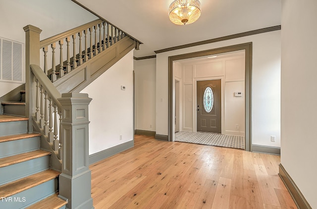 1025 Fairmount Ave, Bristol, VA 24201 - entryway featuring light wood-style floors, baseboards, stairs, ornamental molding, and a chandelier