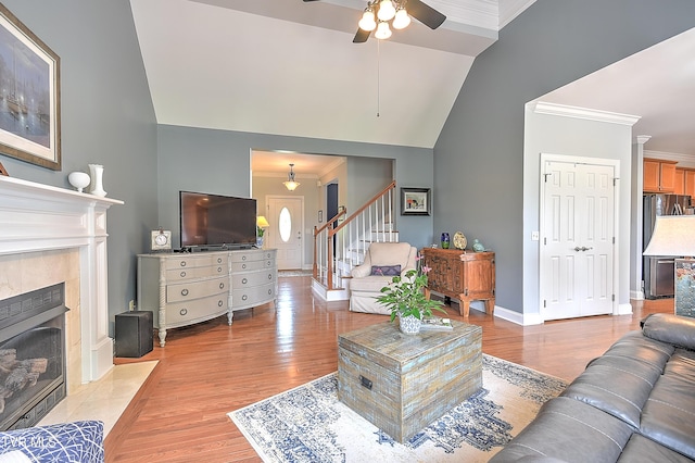 410 Grovemont Pl, Piney Flats, TN 37686 - living area featuring ornamental molding, a tiled fireplace, stairs, a ceiling fan, and light wood-style floors