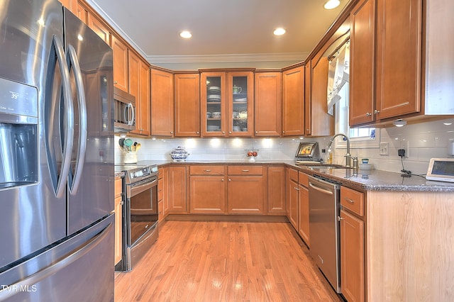 410 Grovemont Pl, Piney Flats, TN 37686 - kitchen with stainless steel appliances, a sink, dark stone counters, light wood finished floors, and brown cabinets
