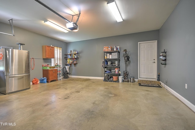 410 Grovemont Pl, Piney Flats, TN 37686 - garage with freestanding refrigerator, a garage door opener, and baseboards