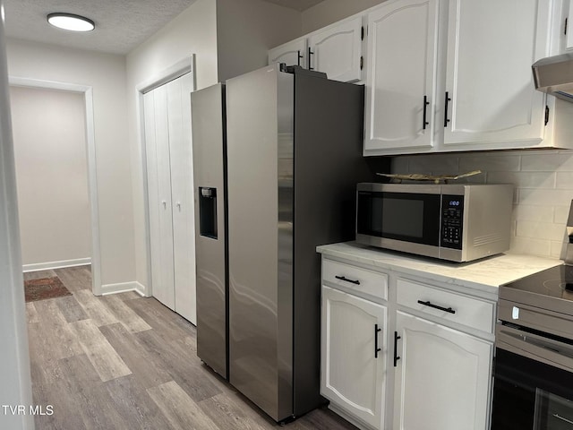 516 Fleetwood Ct Unit F, Kingsport, TN 37660 - kitchen with appliances with stainless steel finishes, decorative backsplash, white cabinetry, light wood-style floors, and light countertops