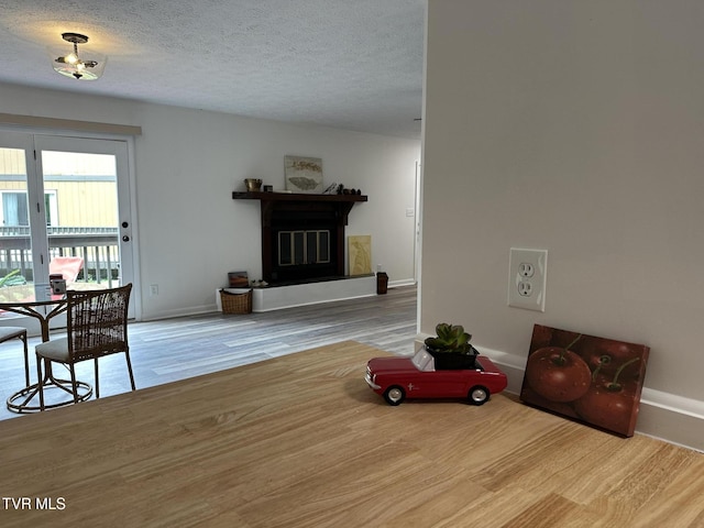 516 Fleetwood Ct Unit F, Kingsport, TN 37660 - living area featuring baseboards, wood finished floors, a glass covered fireplace, and a textured ceiling