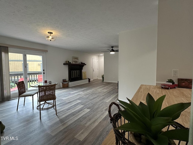 516 Fleetwood Ct Unit F, Kingsport, TN 37660 - dining area featuring wood finished floors, a textured ceiling, a ceiling fan, baseboards, and a glass covered fireplace