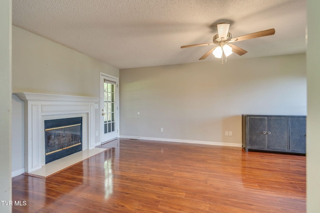 219 Meridale Dr, Johnson City, TN 37601 - unfurnished living room with ceiling fan, wood finished floors, a glass covered fireplace, a textured ceiling, and baseboards