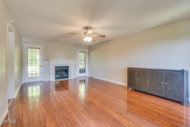 219 Meridale Dr, Johnson City, TN 37601 - unfurnished living room with a ceiling fan, plenty of natural light, wood finished floors, and a textured ceiling