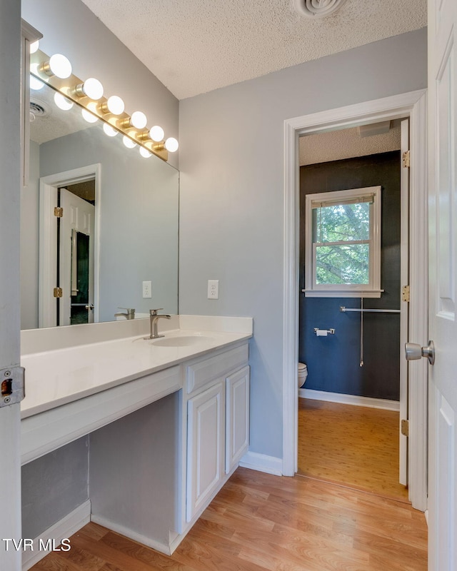 219 Meridale Dr, Johnson City, TN 37601 - bathroom featuring vanity, toilet, wood finished floors, a textured ceiling, and baseboards