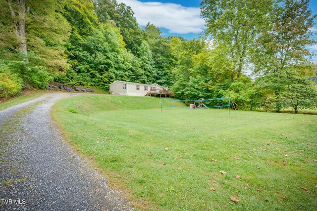 6855 Gate City Hwy, Bristol, VA 24202 - view of grassy yard with gravel driveway, a forest view, and volleyball court