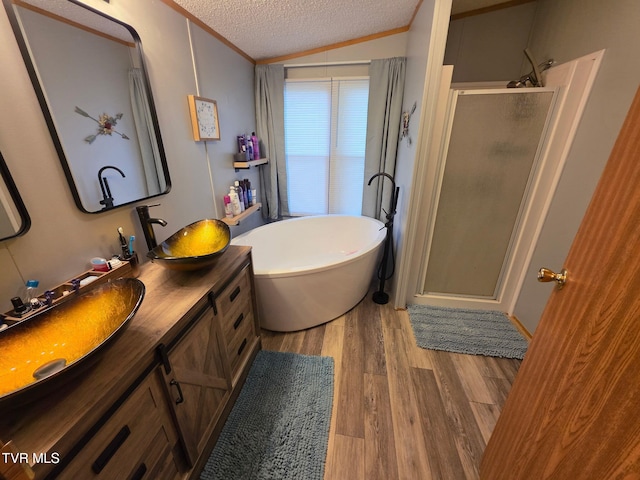 6855 Gate City Hwy, Bristol, VA 24202 - bathroom featuring double vanity, a textured ceiling, a stall shower, lofted ceiling, and wood finished floors