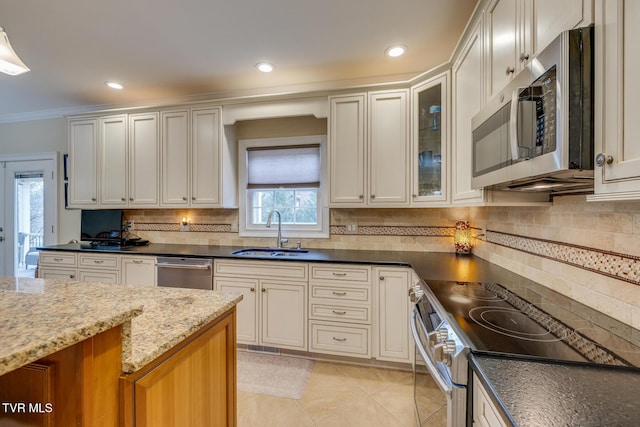 2001 Springfield Ave, Kingsport, TN 37664 - kitchen featuring appliances with stainless steel finishes, a sink, backsplash, dark stone counters, and ornamental molding