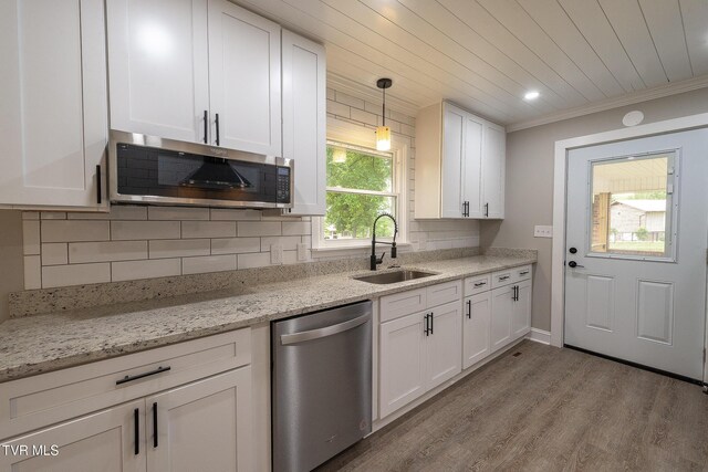 1236 Nassau Dr, Kingsport, TN 37660 - kitchen with appliances with stainless steel finishes, a sink, white cabinetry, tasteful backsplash, and wood finished floors