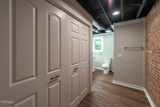 1236 Nassau Dr, Kingsport, TN 37660 - bathroom featuring brick wall, toilet, wood finished floors, and baseboards