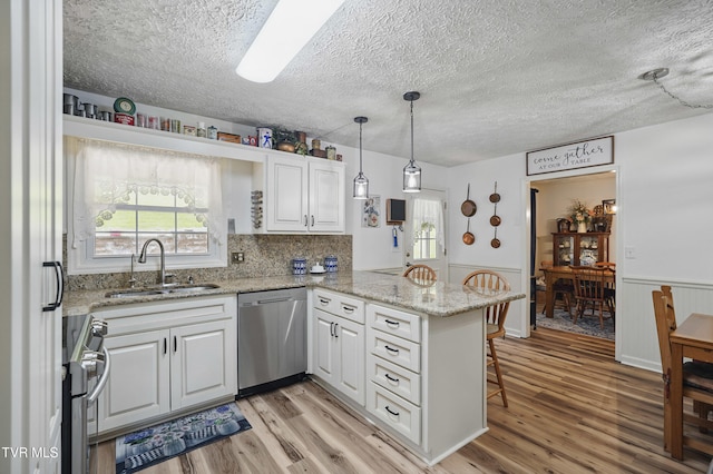 5009 Surrey Dr, Kingsport, TN 37664 - kitchen featuring dishwasher, a sink, a peninsula, stove, and white cabinets