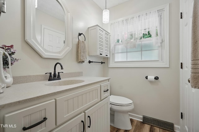 5009 Surrey Dr, Kingsport, TN 37664 - bathroom with toilet, vanity, wood finished floors, and baseboards