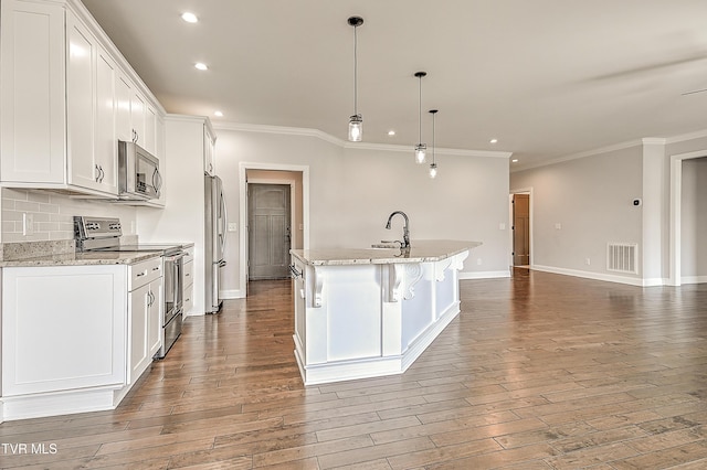 1030 Savin Fls, Gray, TN 37615 - kitchen with appliances with stainless steel finishes, recessed lighting, crown molding, an island with sink, and white cabinets