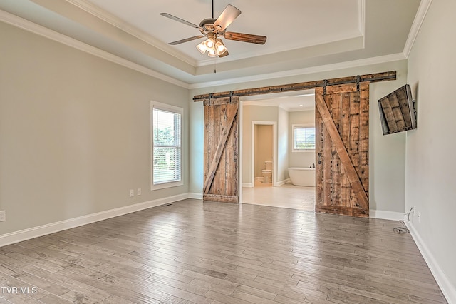 1030 Savin Fls, Gray, TN 37615 - spare room with a barn door, a tray ceiling, ornamental molding, wood finished floors, and ceiling fan