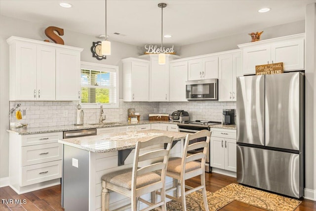 3321 Cottage Green Ct, Kingsport, TN 37664 - kitchen with appliances with stainless steel finishes, a sink, white cabinets, dark wood-type flooring, and a kitchen island
