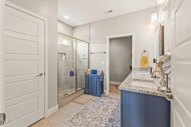3321 Cottage Green Ct, Kingsport, TN 37664 - bathroom with a shower stall, double vanity, baseboards, and wood finished floors