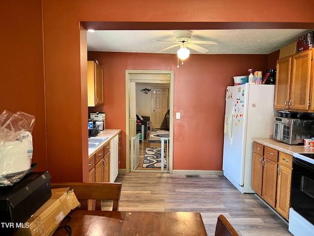 326 Park Ave, Appalachia, VA 24216 - kitchen featuring a ceiling fan, white appliances, light wood-type flooring, light countertops, and brown cabinets