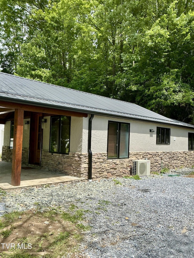 153 Hampton Creek Rd, Roan Mountain, TN 37687 - view of side of property featuring ac unit, stone siding, stucco siding, and metal roof