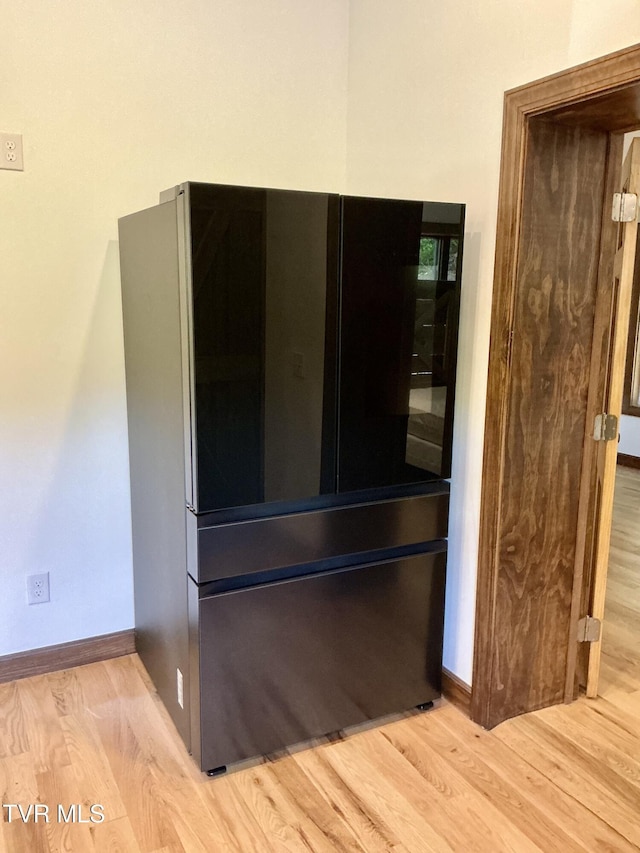 153 Hampton Creek Rd, Roan Mountain, TN 37687 - detailed view of freestanding refrigerator, wood finished floors, and baseboards
