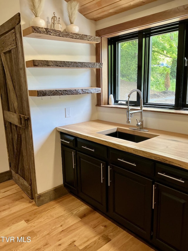 153 Hampton Creek Rd, Roan Mountain, TN 37687 - kitchen with a sink, light wood-type flooring, light countertops, open shelves, and dark cabinetry